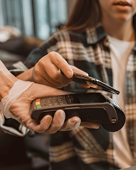 A customer paying contactless with a phone at a card terminal