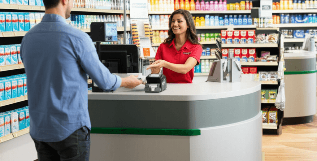 A clerk serving a customer at a store cash counter